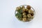 Fermented green cherry tomatoes with dill in a glass plate on a white background