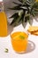 Fermented kombucha pineapple summer drink on a white plate next to the ingredients. Vertical photo.