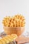 Ferratelle or pizzelle a traditional dessert or cookies from Abruzzo in a bowl on white wooden background, copy space