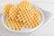 Ferratelle or pizzelle a traditional dessert or cookies from Abruzzo on a plate on a white wooden background, close up