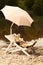 Ferret enjoying relaxation on beach chair with umbrella