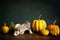 A ferret or polecat puppy in a stillife scene with pumpkins against a green background