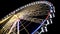 Ferris wheel at amusement park, colorful illuminated construction, bottom view