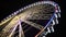 Ferris wheel at amusement park, colorful illuminated construction moving slowly