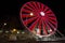 Ferris wheel with colored lights in `Porto Antico` harbor zone in Genoa, Italy