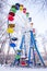 Ferris wheel with colorful booths under the snow closed