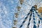 Ferris wheel detail low-angle view by white patchy clouds