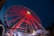 a ferris wheel illuminated in red color overview at night