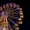 Ferris wheel with lights backlighting the night sky