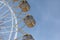 Ferris wheel with the round closed cabins against the backgroun