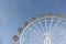 Ferris wheel with the round closed cabins against the sky