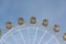 Ferris wheel with the round closed cabins against the sky