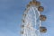 Ferris wheel with the round closed cabins against the sky