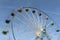 Ferris wheel with round open cabins against of the blue sky