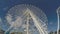 Ferris Wheel stands high on blue skies in an amusement theme park