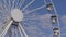 Ferris wheel on street fair over blue sky with white clouds