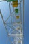 Ferris wheel with yellow and green booths against a blue sky