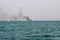 Ferry boat of Bay of Bengal smoke coming from its chimney. Black exhaust fumes coming from the chimney of a moored tanker.