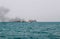 Ferry boat of Bay of Bengal smoke coming from its chimney. Black exhaust fumes coming from the chimney of a moored tanker.