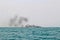 Ferry boat of Bay of Bengal smoke coming from its chimney. Black exhaust fumes coming from the chimney of a moored tanker.