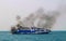 Ferry boat of Bay of Bengal smoke coming from its chimney. Black exhaust fumes coming from the chimney of a moored tanker.