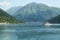 Ferry boat carrying cars between the two banks of Bay of Kotor, or Kotorska Boka, in the afternoon in the waters of the Adriatic