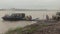 Ferry boat reaching pier in the rain and passengers getting out on motorcycle