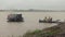 Ferry boat reaching pier in the rain and people waiting at pier for river crossing