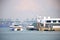 Ferry boats at a harbour with freight container ships in the backdrop