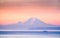 A ferry crossing the Puget Sound at sunrise with Mount Rainier i