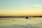 A ferry departs from the dock in the placid waters of the lake at sunset