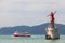 Ferry by Haeundae Cruise sails near red lighthouse sculpture