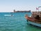 Ferryboat with turkish flag and man riding a hydrocycle against Maiden`s castle or Kizkalesi or Deniz kalesi