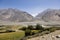 Fertile Wakhan Valley with Panj river near Vrang in Tajikistan. The mountains in the background are the Hindu Kush in Afghanistan