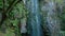 Fervenza de Augacaída Waterfall Flowing In Mossy Rock Cliff. Pullback Shot