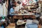 Fes, Morocco - January 07, 2020: Two unknown men working in small leather crafts workshop at old desk, various handmade goods