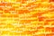 Festive abstract textured background. White curlicues on a yellow and orange background. Swirl pattern. Christmas lights