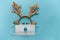 Festive antlers in a mask on a blue background.Christmas and new year 2021