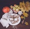 Festive apple pie with powdered sugar close-up with autumn leaves and pumpkin on the table