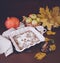 Festive apple pie with powdered sugar close-up with autumn leaves and pumpkin on the table