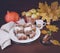 Festive apple pie with powdered sugar close-up with autumn leaves and pumpkin on the table