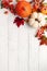 Festive autumn decor from pumpkins, berries and leaves on a white  wooden background. Concept of Thanksgiving day or Halloween.