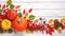 Festive autumn decor from pumpkins, berries and leaves on a white wooden background. Concept of Thanksgiving day or Halloween.