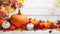 Festive autumn decor from pumpkins, berries and leaves on a white wooden background. Concept of Thanksgiving day or Halloween.