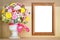 Festive background, card with a bouquet of plastic flowers and wooden frame for text for women`s day,