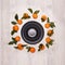 Festive background from mandarins with leaves and black empty plates and bowl