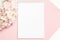 Festive background in pastel colors branch of delicate artificial hydrangea on a pink background with a notebook for writing the t