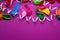 Festive background of purple material colorful balloons streamers confetti Top view flat lay copy space