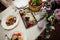 Festive banquet served table. On it are candles, glasses, vegetables, meat, fish, herbs, sandwiches, tomatoes, onions in plates.