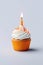 festive birthday cupcake with burning candle